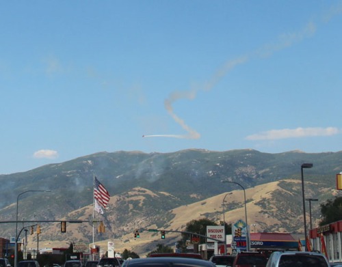 Biplane spewing smoke over Bountiful, Utah just before Pioneer Day festivities -- photo by M.E.